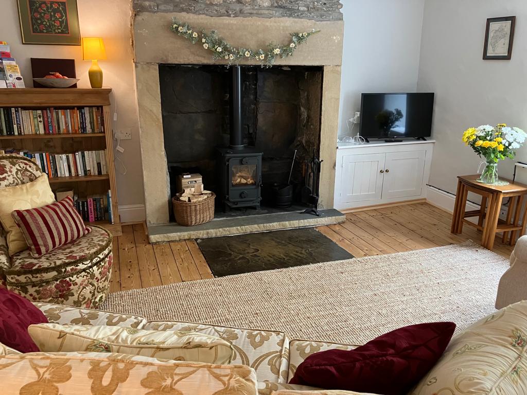 View of the comfortable and cosy lounge with multifuel stove in The Nookery holiday cottage in Alston, Cumbria